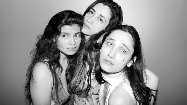Schwarz-Weiß-Foto der drei Performerinnen des Stücks, die mit betont traurigen Blicken in Richtung Kamera schauen, auf ihren Wangen sind künstliche Tränen zu sehen.